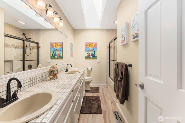 2444 220th Pl NE, Sammamish, WA 98074 - full bath with double vanity, wood finished floors, a skylight, enclosed tub / shower combo, and decorative backsplash