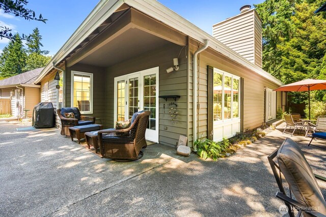 2444 220th Pl NE, Sammamish, WA 98074 - rear view of house featuring a patio area, a chimney, an outdoor living space, and french doors