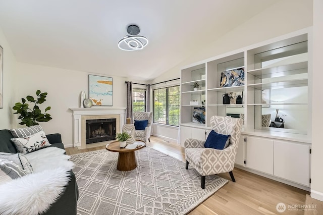 16142 SE 33rd Ln, Unit Bellevue, WA 98008 - living room featuring light wood-style floors, a tiled fireplace, and lofted ceiling