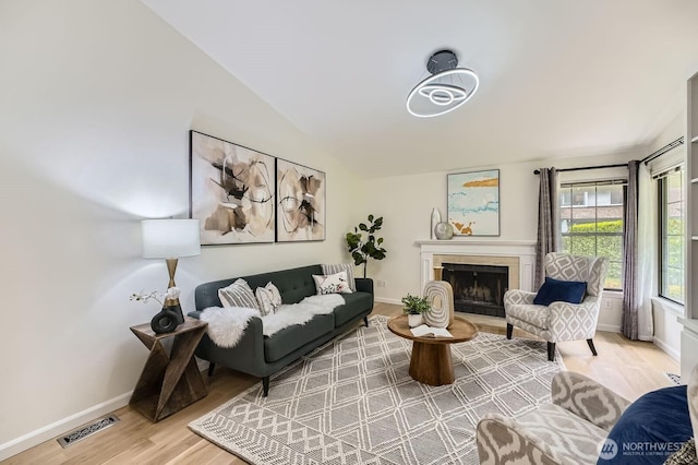 16142 SE 33rd Ln, Unit Bellevue, WA 98008 - living area featuring wood finished floors, a fireplace, and vaulted ceiling