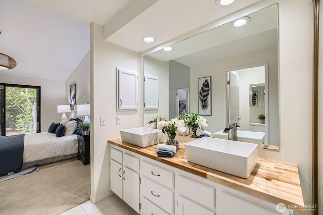 16142 SE 33rd Ln, Unit Bellevue, WA 98008 - ensuite bathroom featuring double vanity, recessed lighting, tile patterned flooring, and lofted ceiling