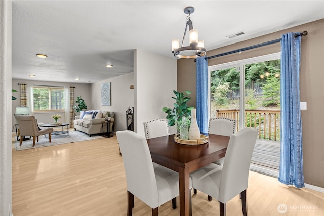 19221 Patterson Rd E, Orting, WA 98360 - dining space with light wood-style flooring and a chandelier