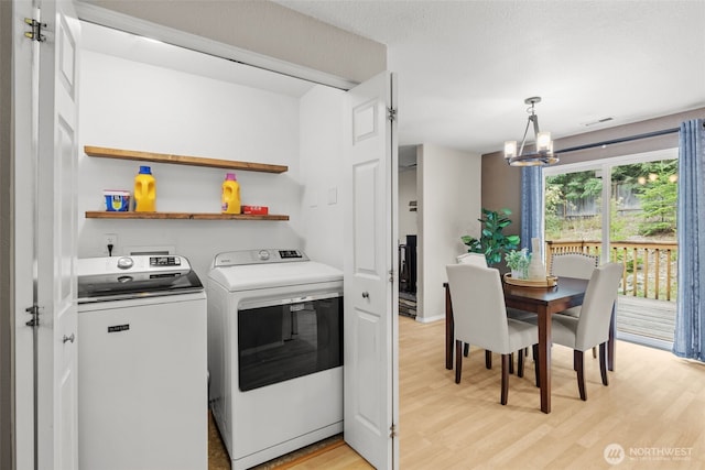 19221 Patterson Rd E, Orting, WA 98360 - laundry area with light wood-style flooring, a chandelier, and independent washer and dryer