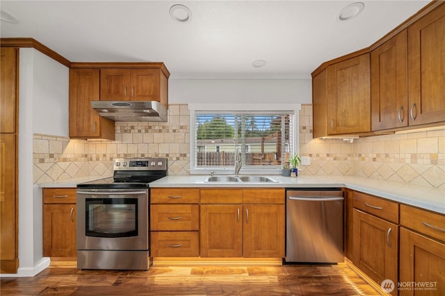 4248 A St SE Unit 423, Auburn, WA 98002 - kitchen featuring stainless steel appliances, under cabinet range hood, brown cabinetry, and ornamental molding