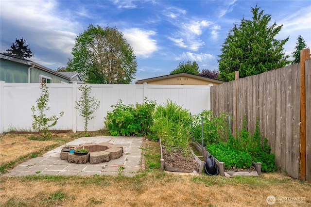 4248 A St SE Unit 423, Auburn, WA 98002 - fenced backyard with a vegetable garden, a patio area, and a fire pit