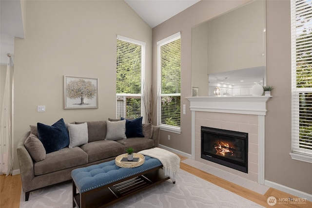 23501 112th Ave SE Unit F103, Kent, WA 98031 - living area with light wood finished floors, a tiled fireplace, healthy amount of natural light, and high vaulted ceiling