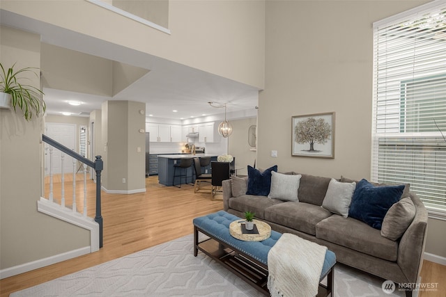 23501 112th Ave SE Unit F103, Kent, WA 98031 - living room featuring light wood-type flooring, a high ceiling, stairs, and recessed lighting