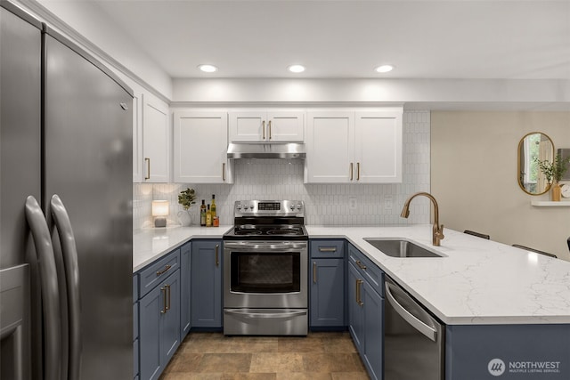 23501 112th Ave SE Unit F103, Kent, WA 98031 - kitchen featuring stainless steel appliances, a peninsula, under cabinet range hood, backsplash, and white cabinets