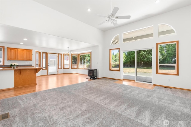 7104 84th St E, Puyallup, WA 98371 - unfurnished living room featuring a wood stove, recessed lighting, light wood-type flooring, a towering ceiling, and ceiling fan