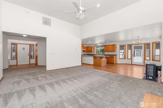 7104 84th St E, Puyallup, WA 98371 - unfurnished living room featuring light carpet, a ceiling fan, recessed lighting, a wood stove, and a high ceiling