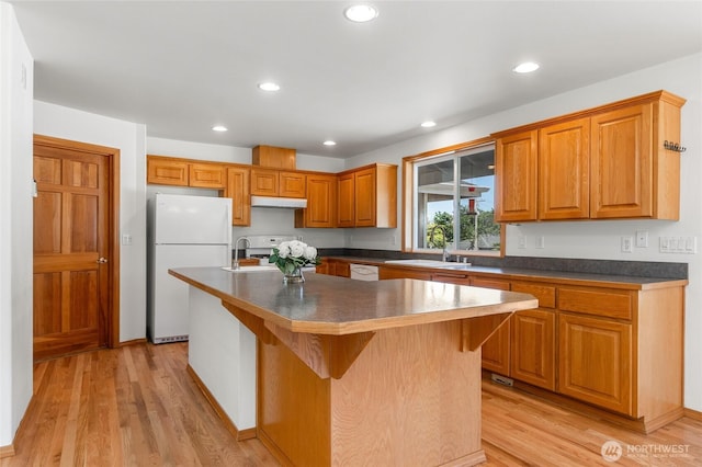 7104 84th St E, Puyallup, WA 98371 - kitchen featuring white appliances, light wood-type flooring, under cabinet range hood, dark countertops, and recessed lighting