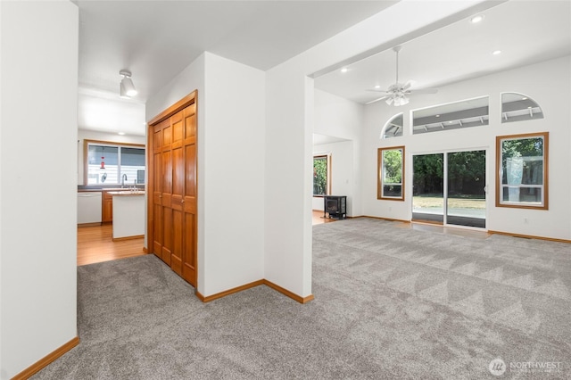 7104 84th St E, Puyallup, WA 98371 - empty room with light carpet, recessed lighting, ceiling fan, and a wood stove
