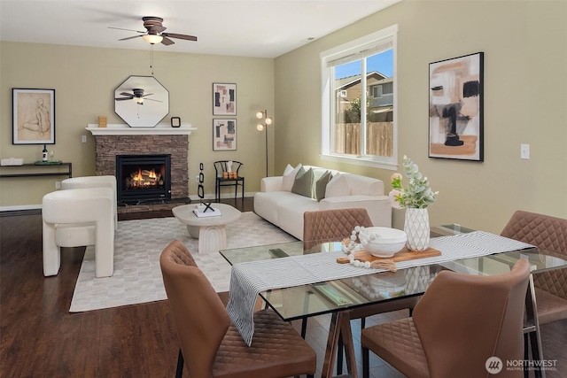 15230 Kayla St SE, Yelm, WA 98597 - living room with wood finished floors, a ceiling fan, and a stone fireplace