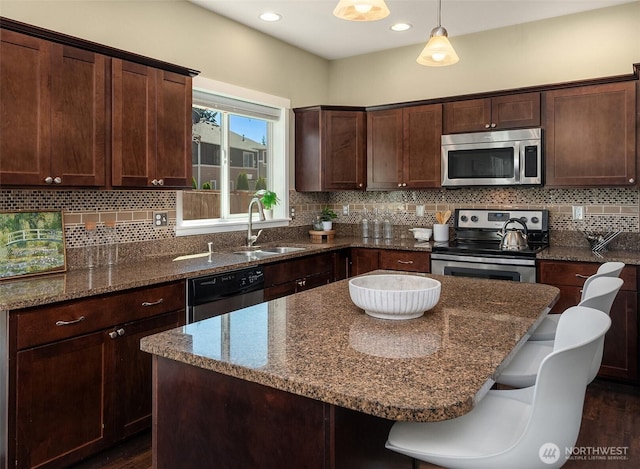 15230 Kayla St SE, Yelm, WA 98597 - kitchen featuring stainless steel appliances, dark wood-style flooring, dark stone countertops, dark brown cabinetry, and backsplash