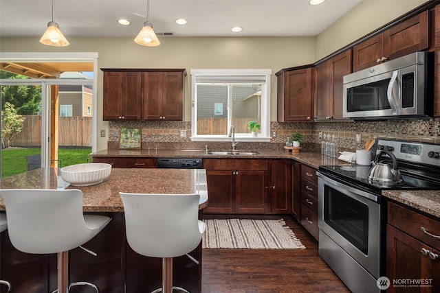 15230 Kayla St SE, Yelm, WA 98597 - kitchen with appliances with stainless steel finishes, dark wood-type flooring, backsplash, dark stone countertops, and recessed lighting