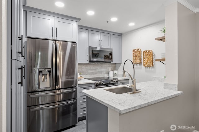 12618 109th Ct NE Unit H102, Kirkland, WA 98034 - kitchen with appliances with stainless steel finishes, a peninsula, gray cabinetry, backsplash, and light stone countertops