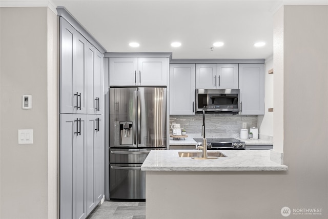 12618 109th Ct NE Unit H102, Kirkland, WA 98034 - kitchen featuring appliances with stainless steel finishes, backsplash, light stone countertops, a peninsula, and gray cabinetry