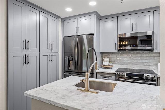 12618 109th Ct NE Unit H102, Kirkland, WA 98034 - kitchen with stainless steel appliances, gray cabinets, tasteful backsplash, light stone counters, and recessed lighting