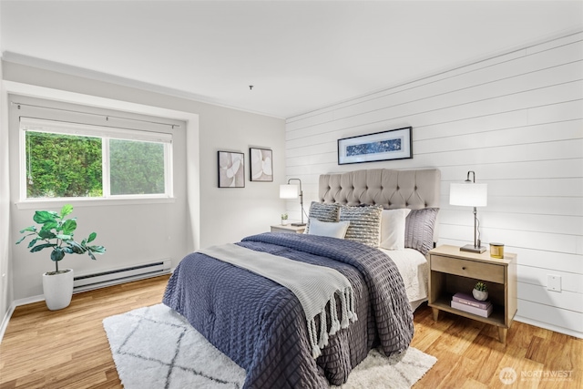 12618 109th Ct NE Unit H102, Kirkland, WA 98034 - bedroom featuring a baseboard heating unit, wooden walls, and light wood finished floors