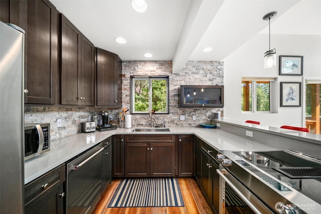 18725 River Rd, Leavenworth, WA 98826 - kitchen with appliances with stainless steel finishes, light wood finished floors, backsplash, dark brown cabinetry, and recessed lighting