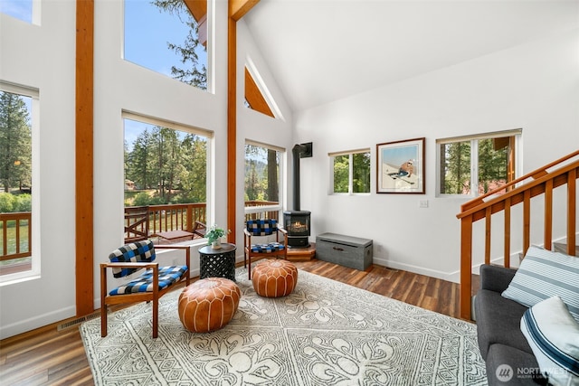 18725 River Rd, Leavenworth, WA 98826 - sitting room with high vaulted ceiling, a wood stove, wood finished floors, healthy amount of natural light, and stairs