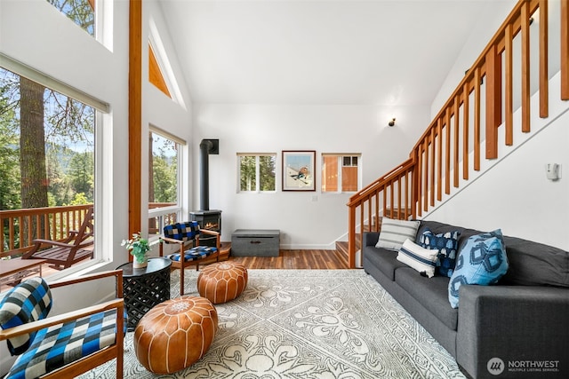 18725 River Rd, Leavenworth, WA 98826 - living room featuring wood finished floors, a wood stove, stairs, and high vaulted ceiling