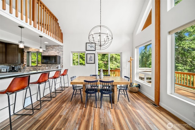 18725 River Rd, Leavenworth, WA 98826 - dining area featuring wood finished floors, high vaulted ceiling, and a chandelier