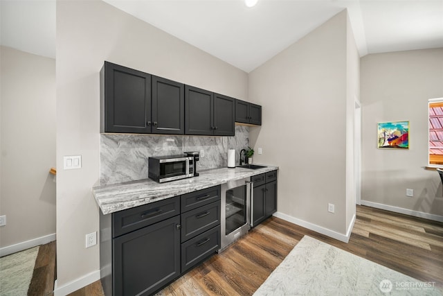 18725 River Rd, Leavenworth, WA 98826 - kitchen with beverage cooler, stainless steel microwave, dark wood-type flooring, tasteful backsplash, and lofted ceiling