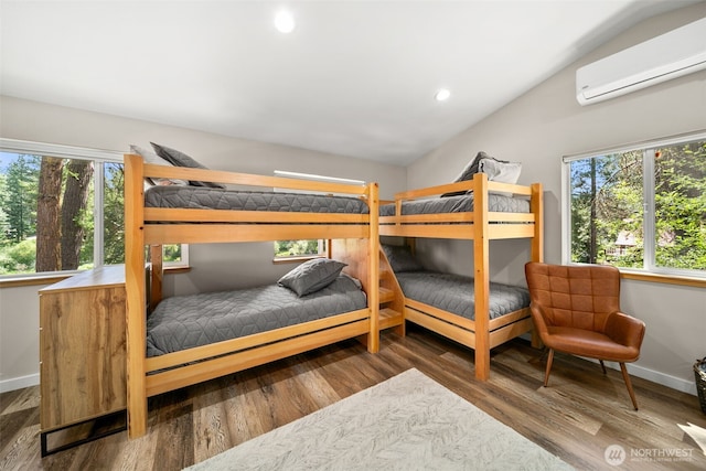 18725 River Rd, Leavenworth, WA 98826 - bedroom with a wall mounted air conditioner, vaulted ceiling, multiple windows, wood finished floors, and recessed lighting