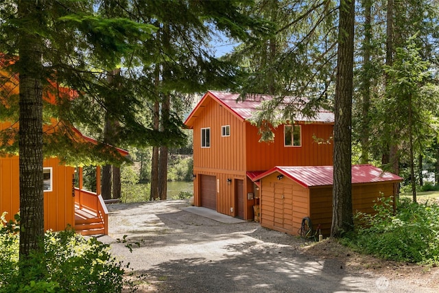 18725 River Rd, Leavenworth, WA 98826 - view of side of property with gravel driveway, an attached garage, and a metal roof