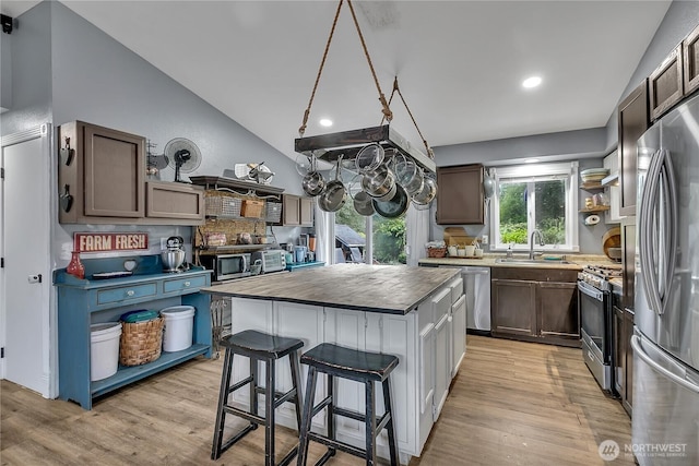 223 Nugget Rd, Gold Bar, WA 98251 - kitchen with appliances with stainless steel finishes, a center island, light wood-type flooring, a kitchen breakfast bar, and lofted ceiling