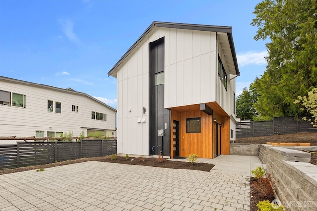 9692 51st Ave S, Seattle, WA 98118 - rear view of house with a patio area and board and batten siding