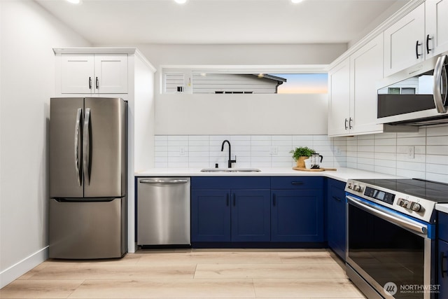 9692 51st Ave S, Seattle, WA 98118 - kitchen with appliances with stainless steel finishes, blue cabinets, recessed lighting, white cabinets, and decorative backsplash