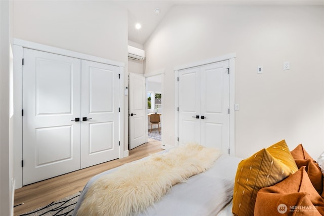 9692 51st Ave S, Seattle, WA 98118 - bedroom with two closets, light wood-type flooring, high vaulted ceiling, an AC wall unit, and recessed lighting