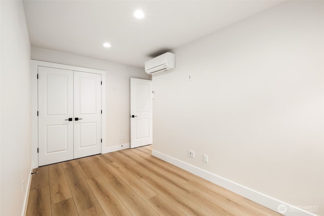 9692 51st Ave S, Seattle, WA 98118 - unfurnished bedroom featuring an AC wall unit, recessed lighting, light wood-style flooring, and a closet