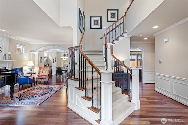 4569 162nd Ln SE, Bellevue, WA 98006 - stairway with arched walkways, ornamental molding, wood finished floors, a wainscoted wall, and recessed lighting