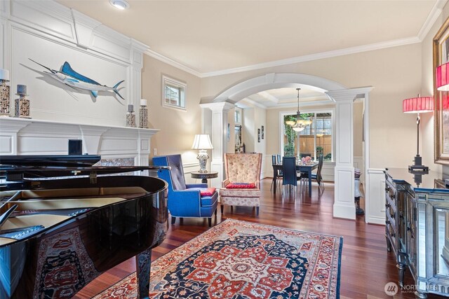 4569 162nd Ln SE, Bellevue, WA 98006 - living room featuring ornate columns, dark wood-style flooring, ornamental molding, arched walkways, and a chandelier