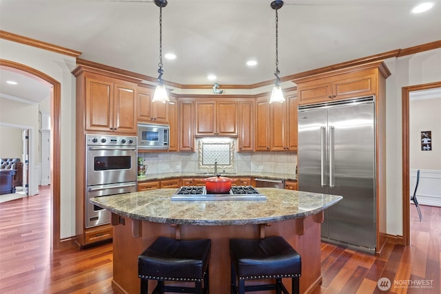 4569 162nd Ln SE, Bellevue, WA 98006 - kitchen with built in appliances, dark wood-style floors, crown molding, a kitchen island, and backsplash