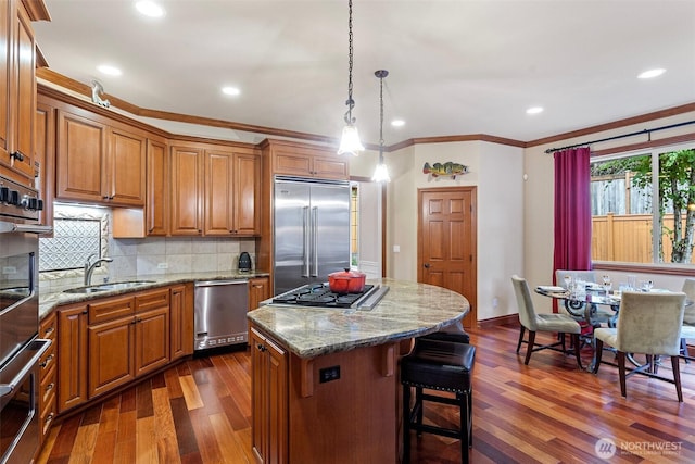 4569 162nd Ln SE, Bellevue, WA 98006 - kitchen featuring stainless steel appliances, brown cabinets, dark wood finished floors, a center island, and crown molding