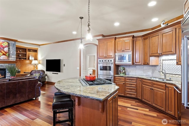 4569 162nd Ln SE, Bellevue, WA 98006 - kitchen with stainless steel appliances, crown molding, open floor plan, light wood-type flooring, and light stone counters