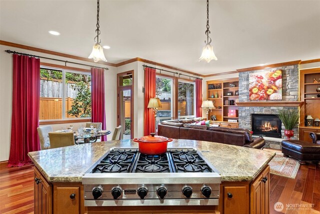 4569 162nd Ln SE, Bellevue, WA 98006 - kitchen featuring stainless steel gas cooktop, ornamental molding, light wood finished floors, a center island, and light stone countertops