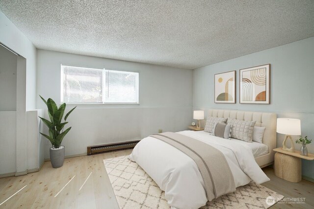 421 S 321st Pl Unit C4, Federal Way, WA 98003 - bedroom with baseboard heating, wood finished floors, and a textured ceiling