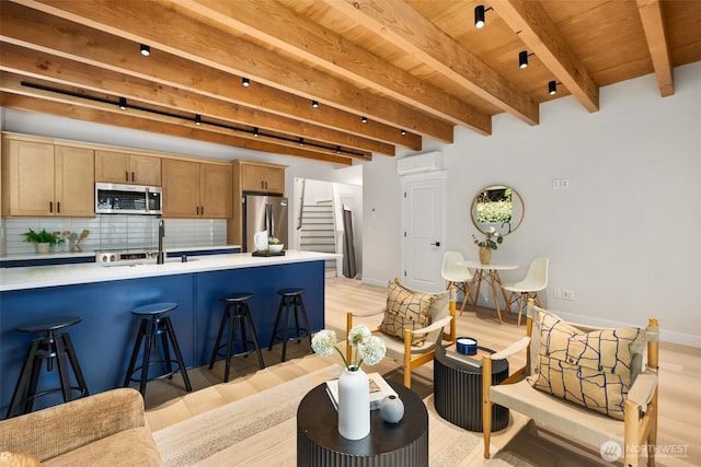 9694 51st Ave S, Seattle, WA 98118 - kitchen with stainless steel appliances, light wood finished floors, a wood ceiling with exposed beams, tasteful backsplash, and a breakfast bar area
