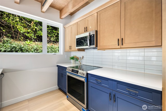 9694 51st Ave S, Seattle, WA 98118 - kitchen with appliances with stainless steel finishes, blue cabinetry, tasteful backsplash, light wood-type flooring, and light countertops