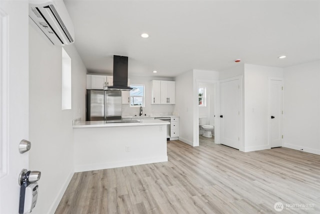 3102 44th Ave NE, Tacoma, WA 98422 - kitchen with ventilation hood, stainless steel fridge, a wall mounted air conditioner, light countertops, and white cabinets