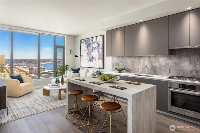 2510 6th Ave Unit 2809, Seattle, WA 98121 - kitchen featuring appliances with stainless steel finishes, modern cabinets, wood finished floors, gray cabinetry, and decorative backsplash