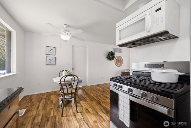 6819 Braker Way, Lynden, WA 98264 - kitchen featuring stainless steel gas range, white microwave, light wood finished floors, and ceiling fan