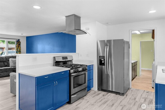 900 Dundee Rd NW, Olympia, WA 98502 - kitchen featuring appliances with stainless steel finishes, island exhaust hood, blue cabinetry, open floor plan, and light wood-style flooring