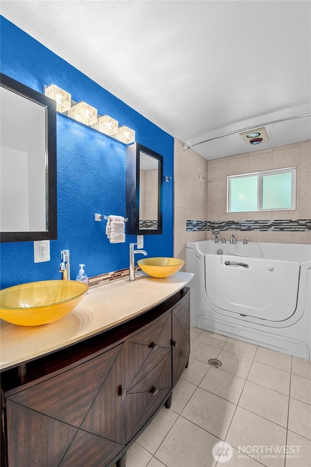 900 Dundee Rd NW, Olympia, WA 98502 - full bath featuring double vanity, a garden tub, tile patterned flooring, and a textured ceiling