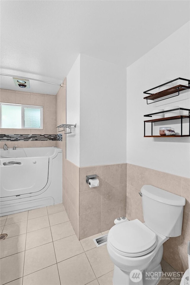 900 Dundee Rd NW, Olympia, WA 98502 - bathroom featuring tile walls, tile patterned floors, washer / dryer, a bidet, and wainscoting